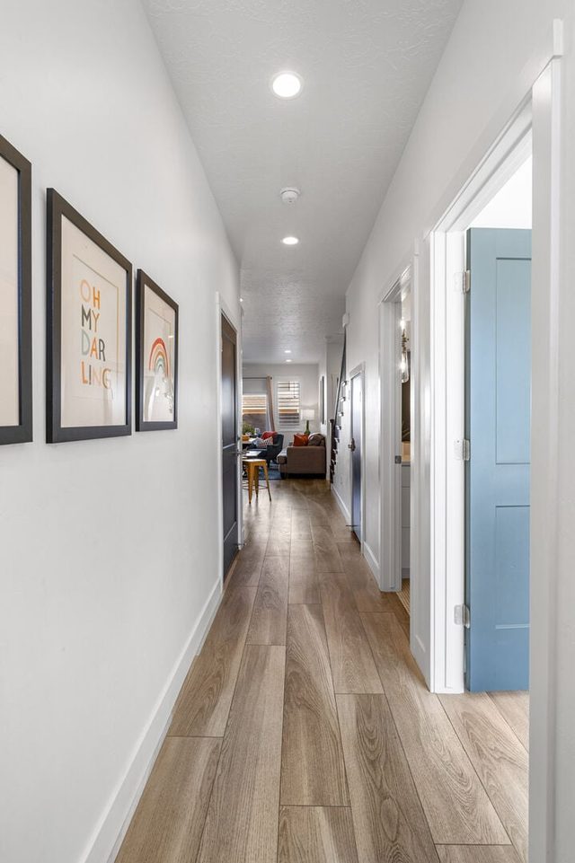 Hallway with framed art leading to the living area