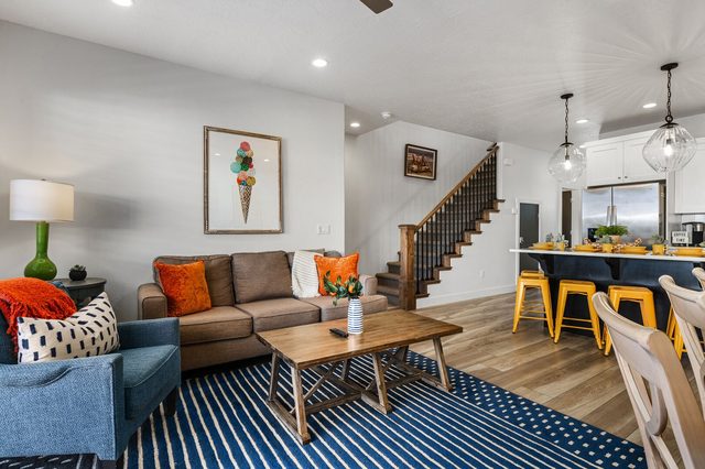 Living room seating with staircase and kitchen island