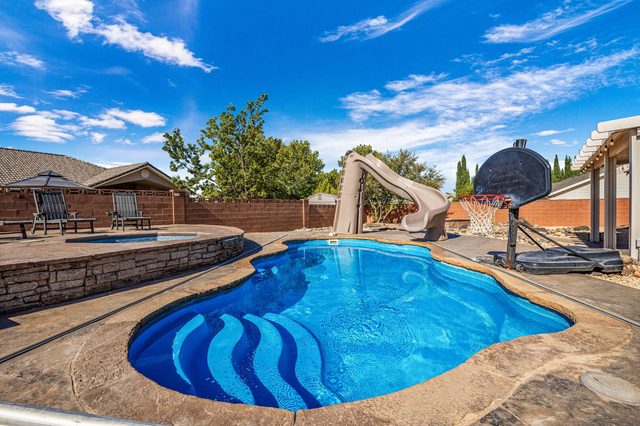 Blue private pool with slide and basketball hoop