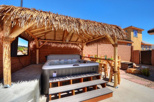 Private hot tub with steps under the thatched tiki hut