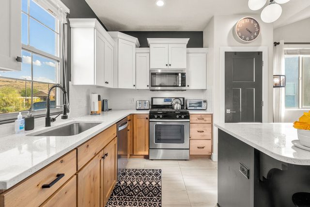 Kitchen with quartz counters, gas range and stainless appliances