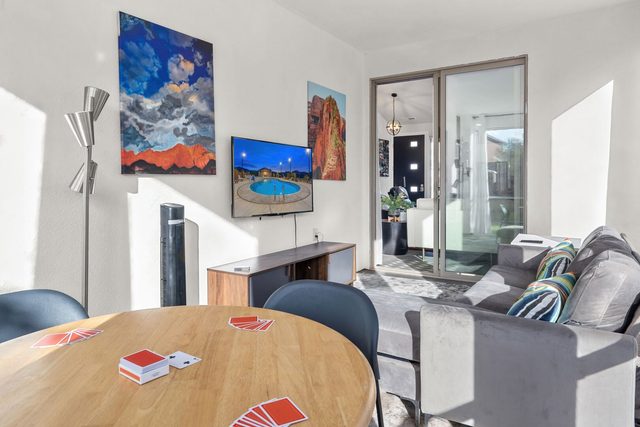 Sun room with card table, sofa and smart TV
