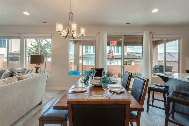Dining table beside kitchen island bar seating and patio doors