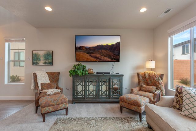 Living room seating with wall-mounted TV and armchairs
