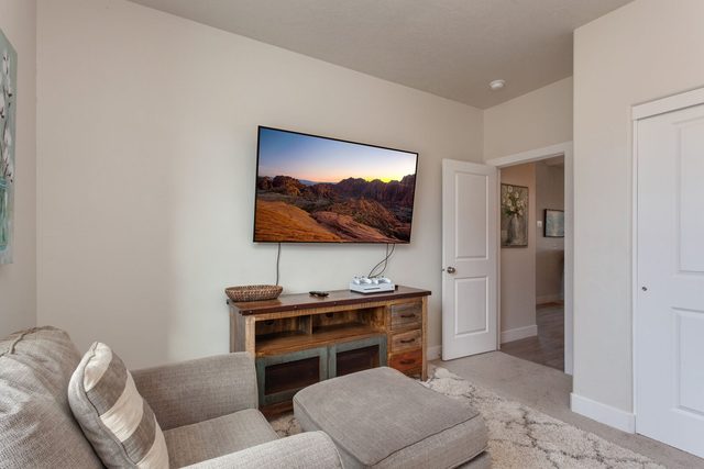 Den lounge with wall-mounted TV and media console