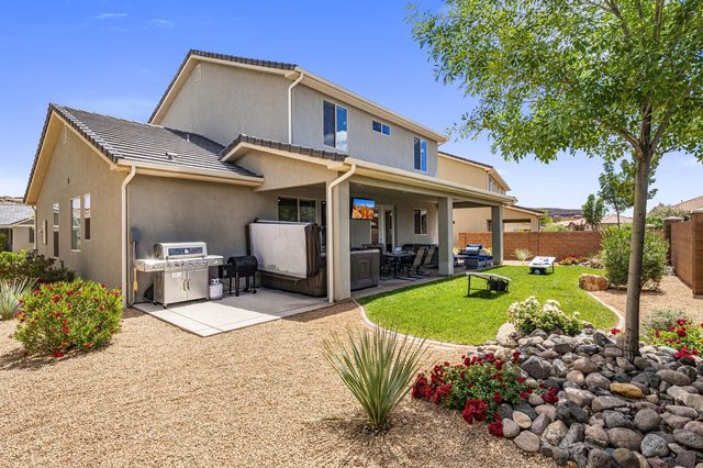 Backyard of Ladera 379 with grill, hot tub and lawn