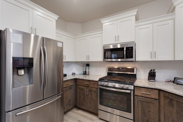 Stainless refrigerator and gas range in kitchen at Ladera 415