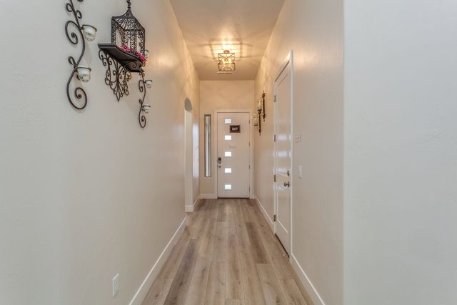 Entry hallway with wood-look floors leading to front door at Ladera 415