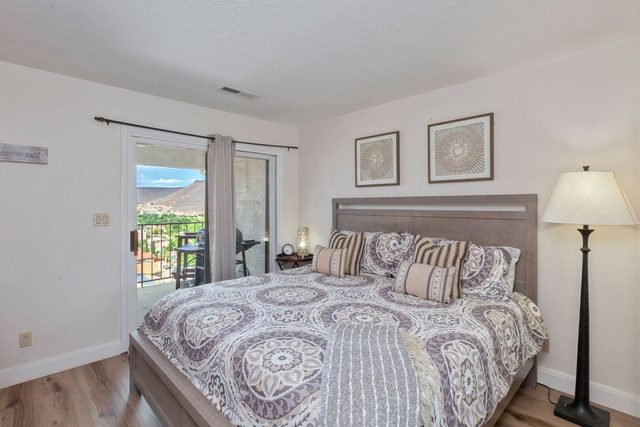 King bedroom with patterned bedding and balcony door at Las Palmas 124