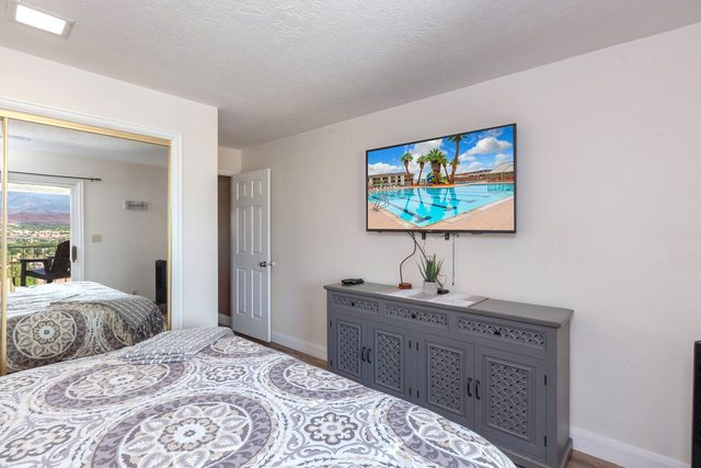 King bedroom with dresser and wall-mounted TV