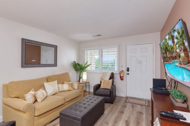 Living room with sofa bed, armchair and wall-mounted TV