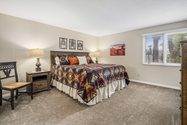 Bedroom with king bed, southwestern bedding and nightstand lamps
