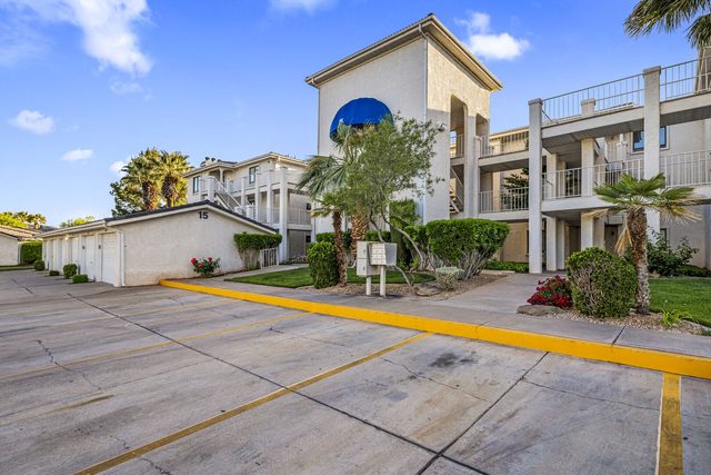 Las Palmas condo building exterior with parking lot and palm trees