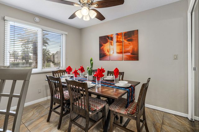 Dining table for six under ceiling fan near the kitchen