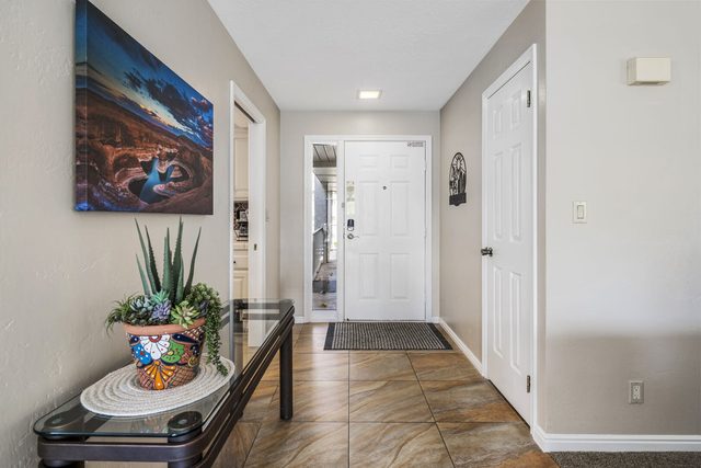 Tiled entry hallway with console table and front door at Las Palmas 1507