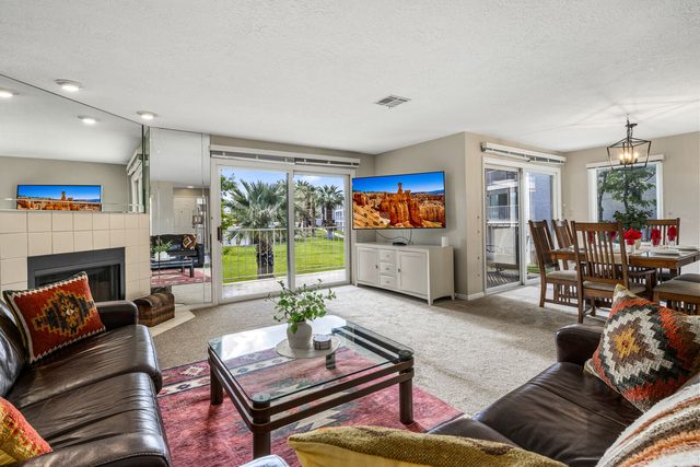 Living room with fireplace, wall TV and patio doors at Las Palmas 1507