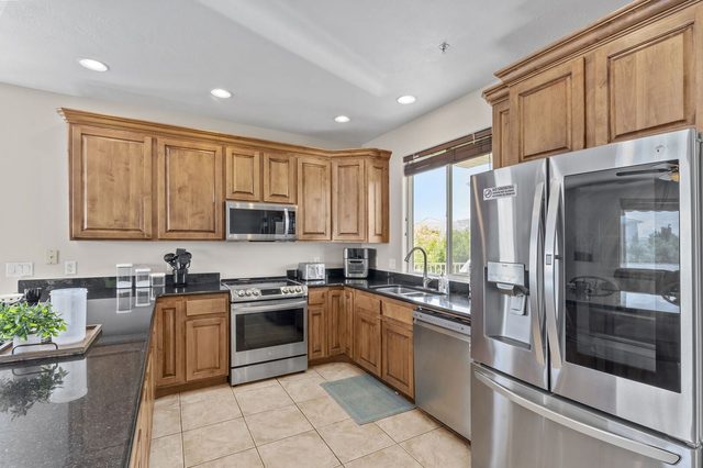 Kitchen with stainless refrigerator, range and wood cabinetry at Las Palmas 1805