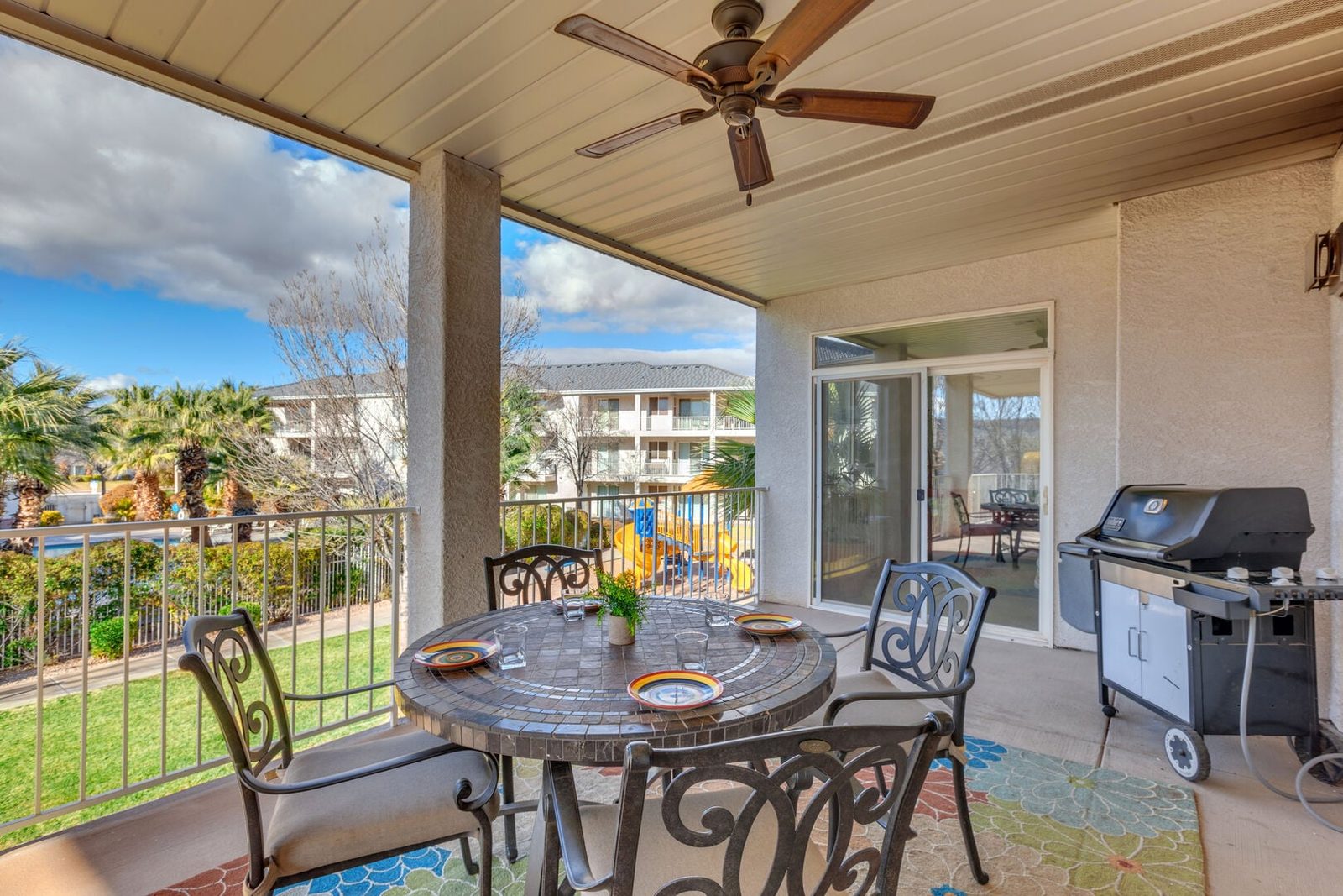Covered balcony dining table and gas grill overlooking the grounds