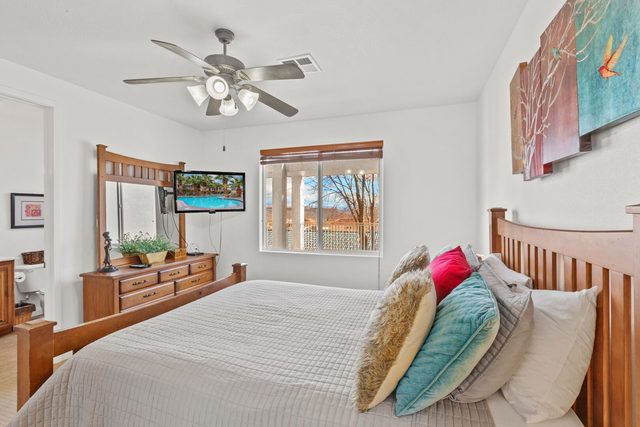Queen bedroom with dresser, mirror and wall TV