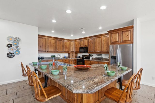 Granite kitchen island with wooden bar chairs