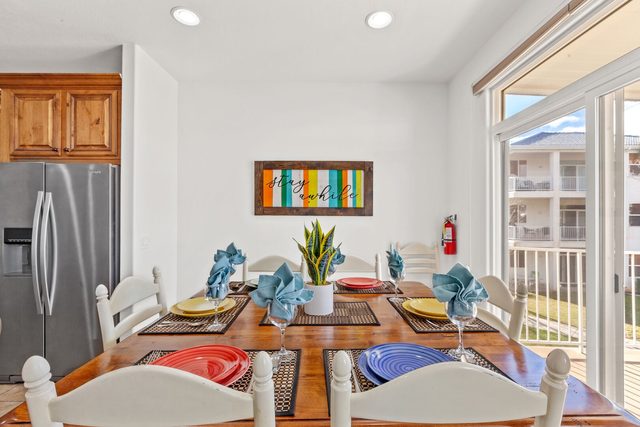 Dining table set for six beside the balcony door
