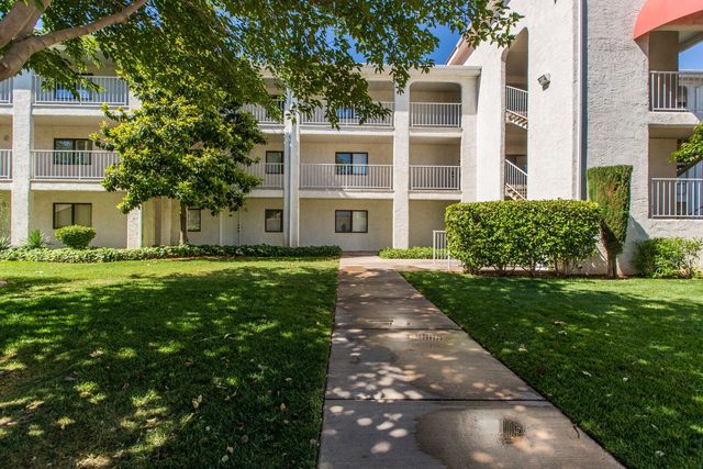 Shaded lawn and walkway leading to the condo building
