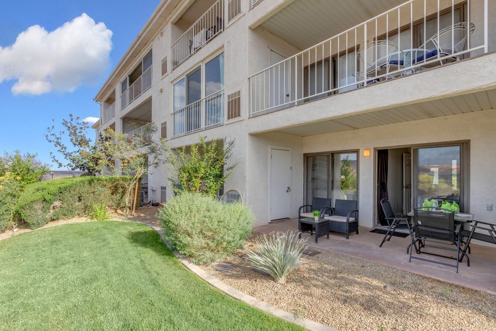Ground-floor patio and lawn outside Las Palmas 304 condo building