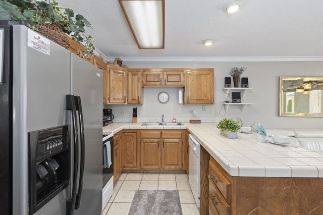 U-shaped kitchen with wood cabinets and tiled counters