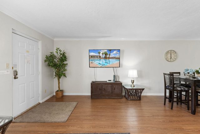Entry and living area with wall TV and dining table