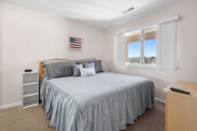 Second bedroom with king bed, gray bedspread and window light