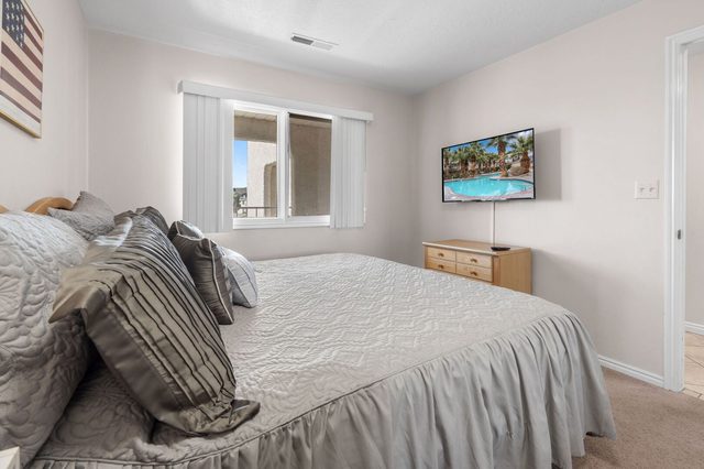 King bedroom with wall-mounted TV and dresser at Las Palmas 326
