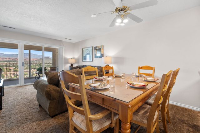 Dining table for six beside sofa and balcony doors at Las Palmas 326