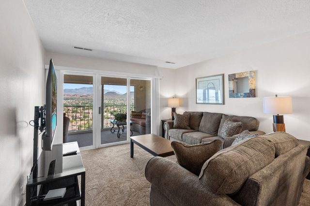 Living room with two sofas, wall TV and balcony sliding doors