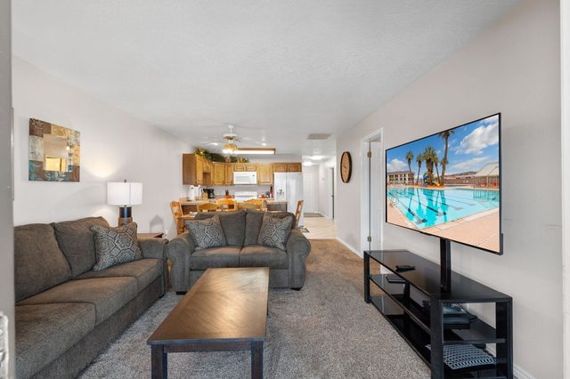 Living room with sectional seating, coffee table and large wall-mounted TV