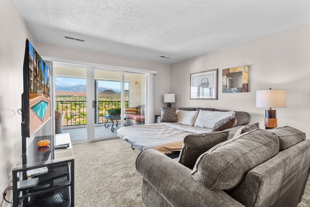 Living room sleeper sofa made up near balcony doors with valley views