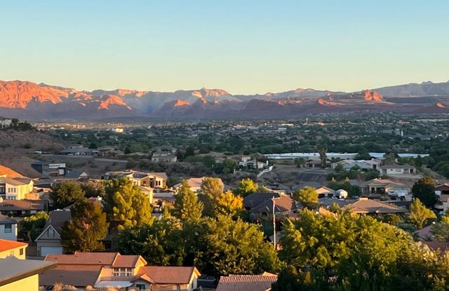 Sunset view over St. George neighborhoods toward red cliffs and mountains