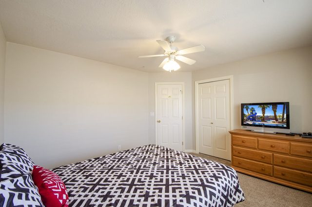 Bedroom with patterned bedding, dresser and TV at Las Palmas 704