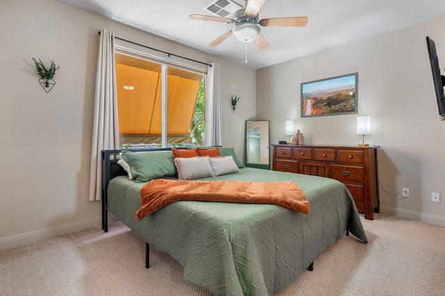 Bedroom with king bed, green bedding and dresser in condo 804