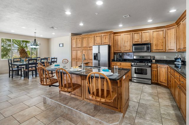 Kitchen with wood cabinets, island seating and stainless appliances in condo 804