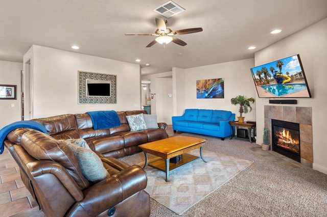 Living room with leather sectional, fireplace and TV in condo 806