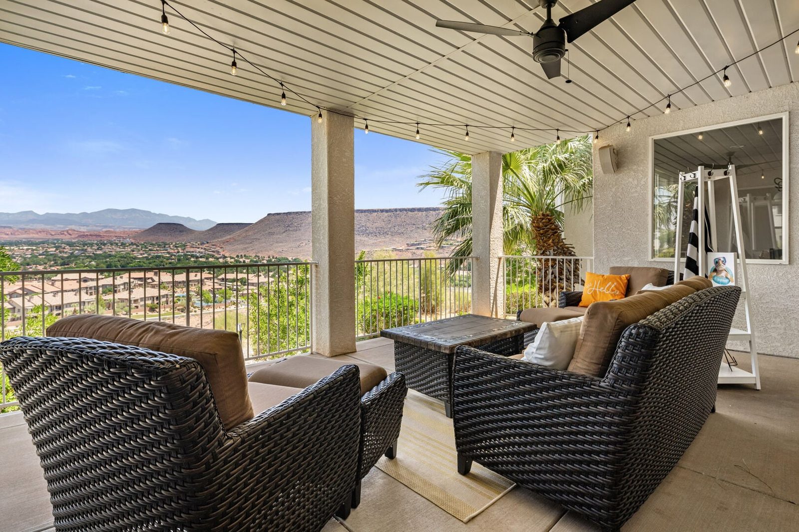 Covered balcony with wicker lounge seating and red rock views at Las Palmas 804