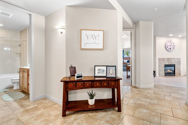 Entry hall with console table leading to living room fireplace