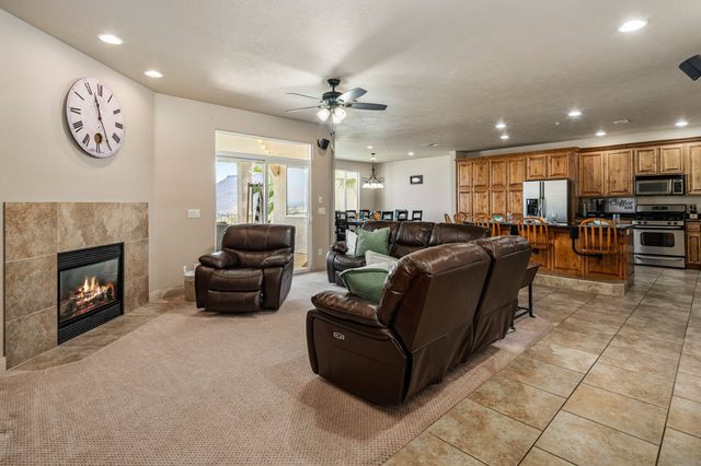 Living room with leather recliners and fireplace open to kitchen