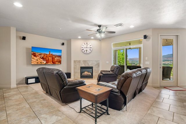 Living room with leather sofas, fireplace, TV and balcony doors