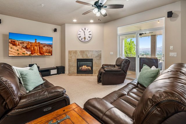 Leather sectional seating facing TV and tiled gas fireplace