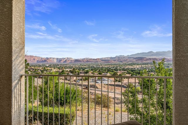 Wide balcony view across the valley to red rock ridges