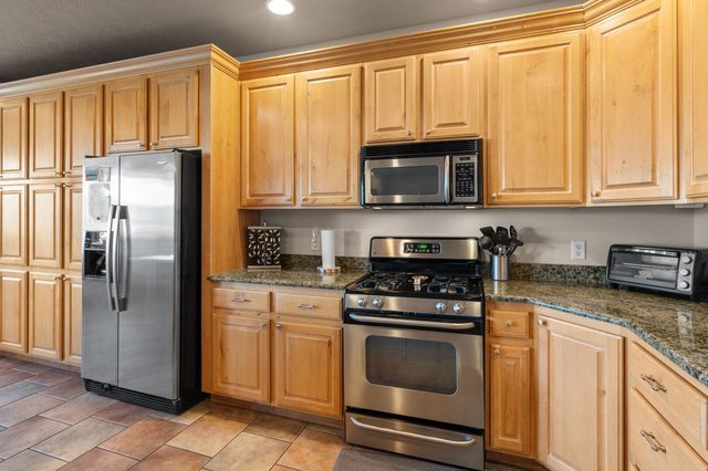 Kitchen with gas range, microwave and stainless steel refrigerator