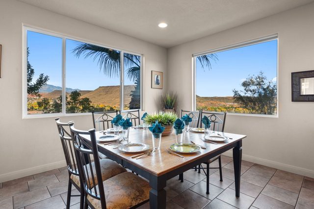 Dining table for six beside large windows with desert views