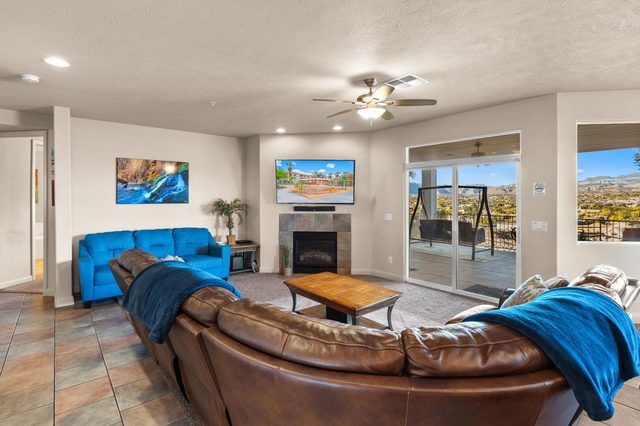 Living room with leather sectional, fireplace and balcony doors at Las Palmas 806