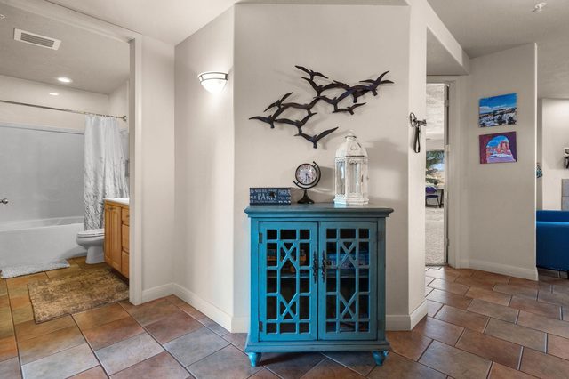 Entry hallway with blue accent cabinet leading to a guest bathroom